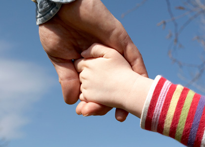 Child holding adult's hand