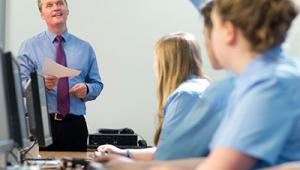Happy teacher in computer class