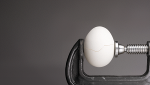 Under pressure.An egg cracking under pressure applied by squeezing clamps form the sides.credit_shutterstock