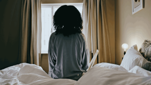 woman sitting bed - credit - istock-1462664399