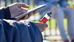 Teenager vaping while using phone Shutterstock 2138631041