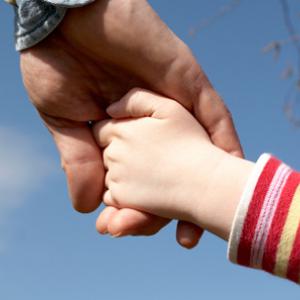 Child holding adult's hand