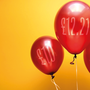 Three shiny red balloons set against a vibrant yellow background.credit_shutterstock_2472941519