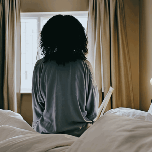 woman sitting bed - credit - istock-1462664399