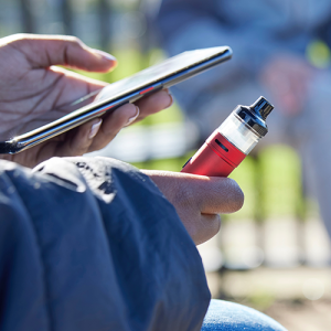 Teenager vaping while using phone Shutterstock 2138631041